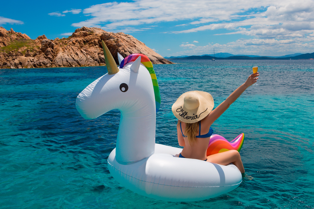 Sardinian summer. Blonde on unicorn. Blue water. 